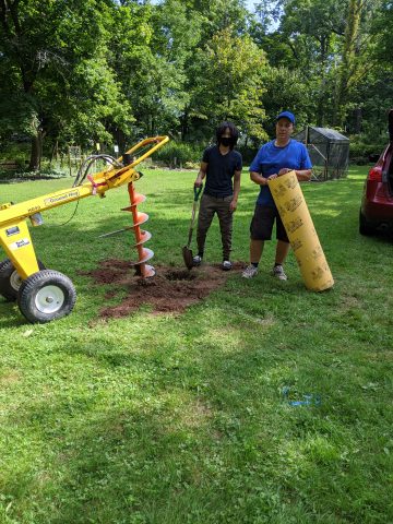 Mr. Kaiser and 8th grader, Jolia work on installing posts for the pavilion.