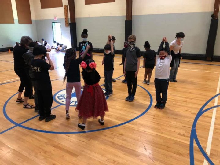 Students acting out a summer activity of watching penguins at the zoo.